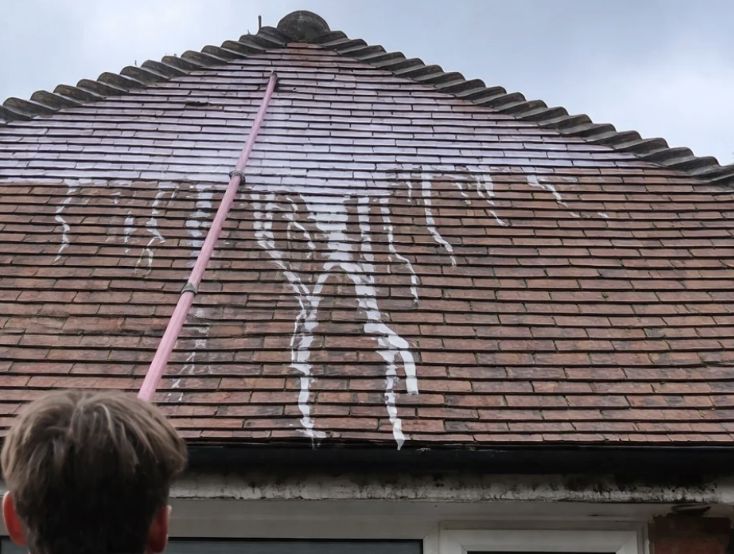Biocide treatment being applied to a roof by Arcline
